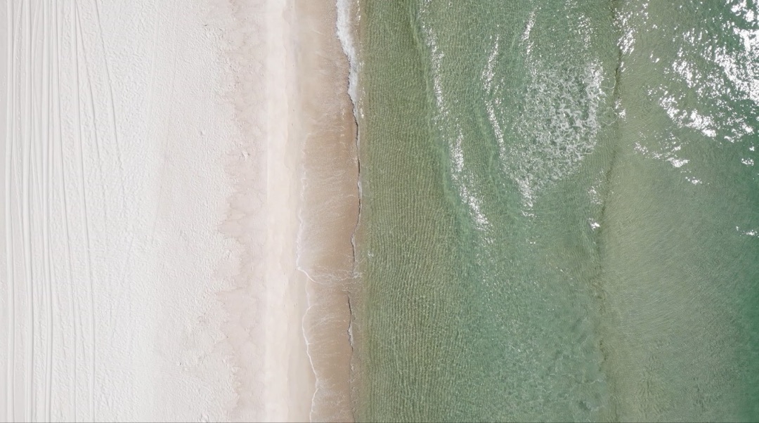 Aerial view of white sand meeting emerald waters