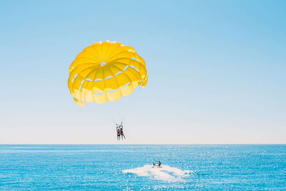 People parasailing, which is one of the many water sports to enjoy in Panama City Beach, Florida.