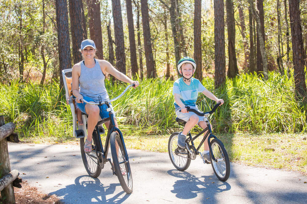 A family riding the Timpoochee Trail, one of the best things to do in Rosemary Beach.